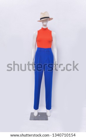 Full mannequin in orange sweater  with blue pants ,hat on white background
