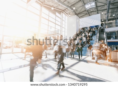 crowd of blurred business people at a trade show, with copy space banner