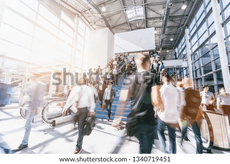 blurred business people at a trade show, with copy space banner