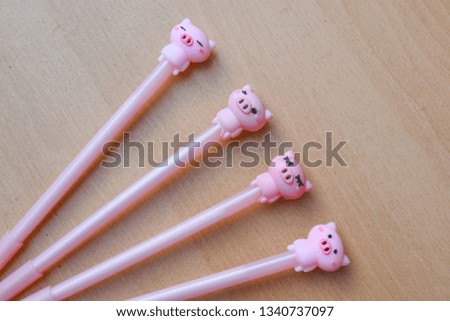 Pink pig shaped pen on a wooden background