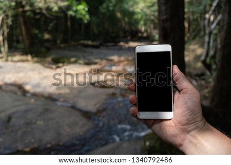 men holding smart phone in tropical forest
