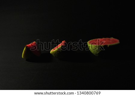 red guava isolated on black background
