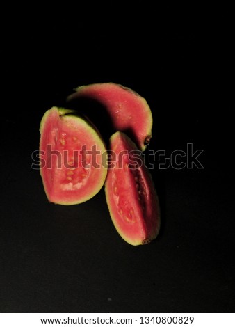 red guava isolated on black background