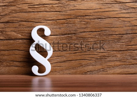 White Paragraph Sign Leaning On Wooden Wall