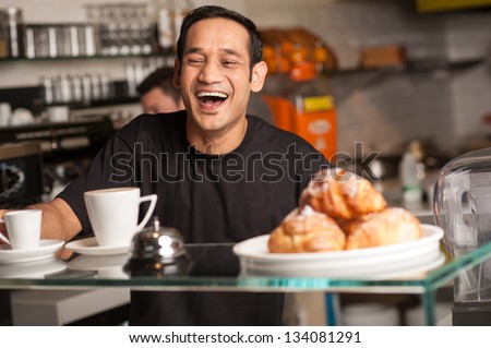 A staff at restaurant bursts out with laughter for a joke cracked by customer. Royalty-Free Stock Photo #134081291