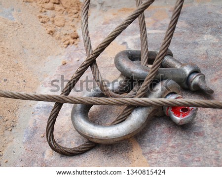 Closeup of steel wire rope with safety anchor shackle bolt for heavy work on construction sites On a metal sheet background.