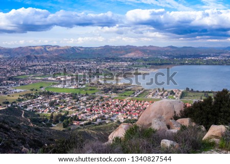 Residential houses in a valley by the lake with mountains on the background. Panoramic view on the city of Lake Elsinore, Southern California USA.