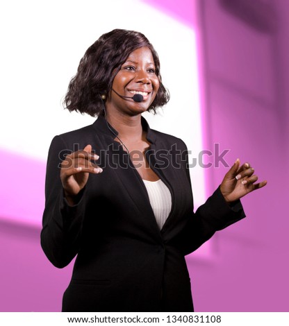young attractive and successful black African American business woman with headset speaking in auditorium at corporate training event or seminar giving motivation and success coaching conference Royalty-Free Stock Photo #1340831108