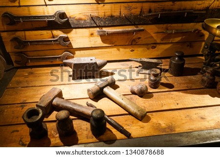 A collection of vintage tools displayed on a background of grey barnboard.