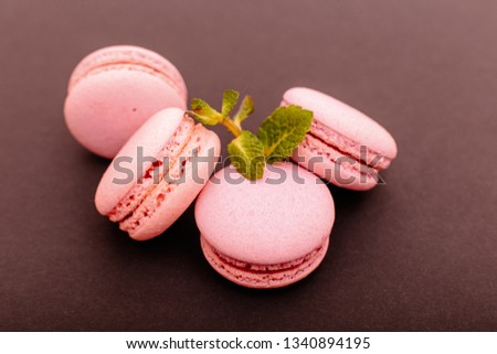 Sweet and colourful french macaroons on a brown background.