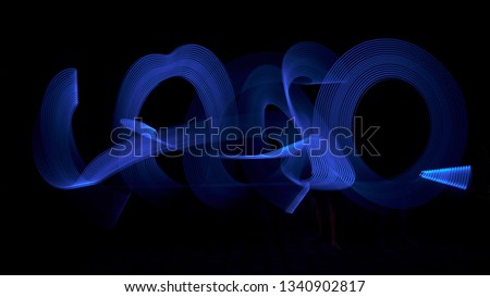 Image of Blue light painting, long exposure photography, abstract swirls and waves against a black background