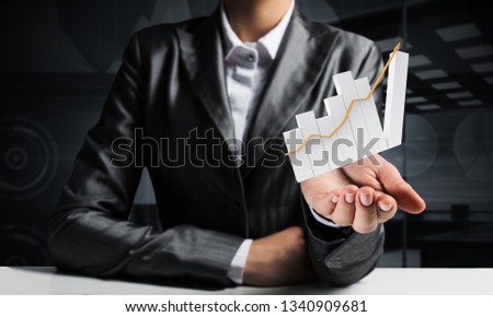 Cropped image of businessman in suit presenting growing graph in his hand with dark office view on background. 3D rendering.