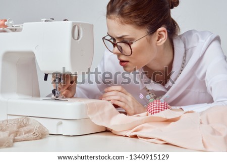  a seamstress sews on a sewing machine                              