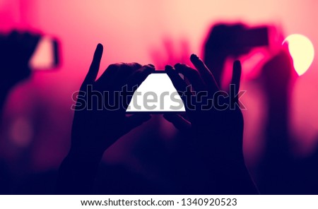 Concert fan filming with smartphone with empty space for logo. Music festival wallpaper template for flyer design. Young people film performance with smartphones