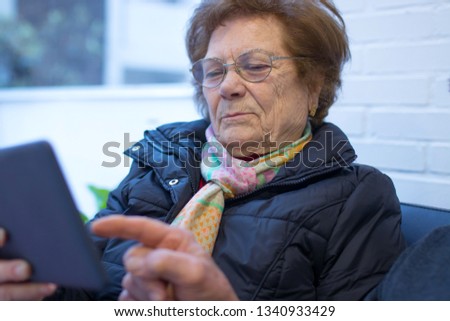 older woman or grandmother with digital or portable tablet