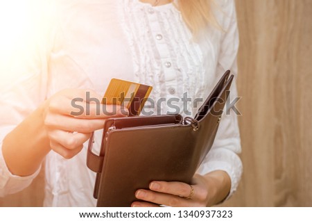 Woman hand pulls out or puts a credit card out of wallet. Photos with flare.