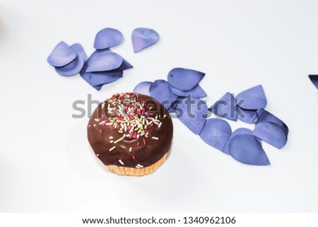 Chocolate cup cake with a white background with petals