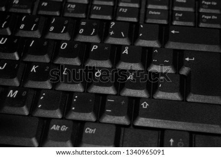 Part of a laptop keyboard. Close up photo in black and white. Contains Scandinavian letters.