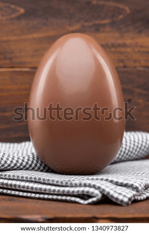 Delicious chocolate Easter holiday egg on rustic background