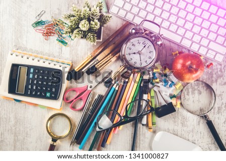 keyboard with stationary and clock on desk

