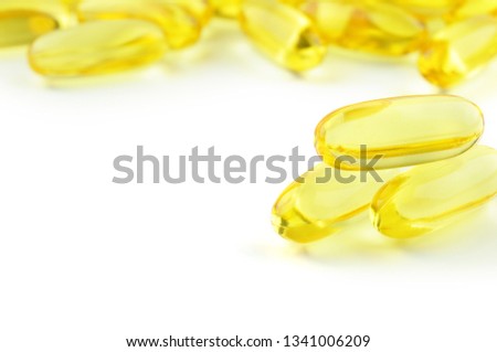 Capsules Omega 3 isolated on white background and many other of capsules on blurred background. Close up, high resolution product. Health care concept.
