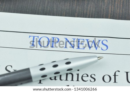 Newspaper and Pen. Heading a Top News in the Newspaper. Concept Top News. Macro photo.
