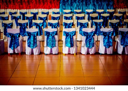 
A white chair and a blue bow tied in a row in the auditorium