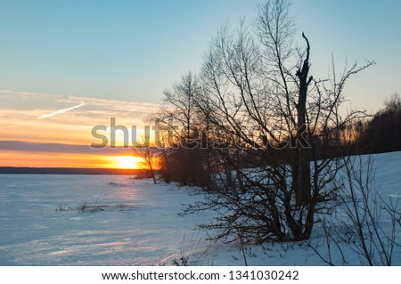 Beautiful sunset on the great Volga river. Lot of ice on the winter river