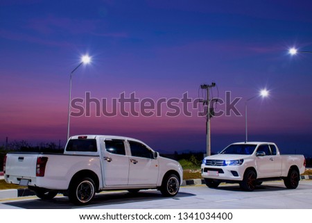 White cars parked on the streets at blue night sky background.