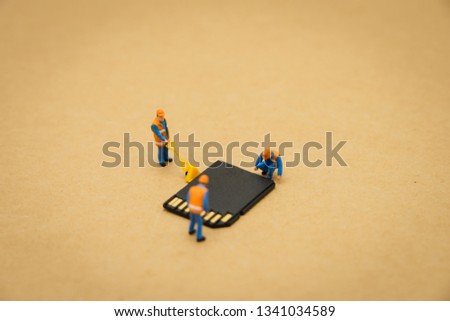 Miniature people Construction worker repair with Storage card or memory card using as background Technology concept and maintenance concept with copy space  for your text or design.