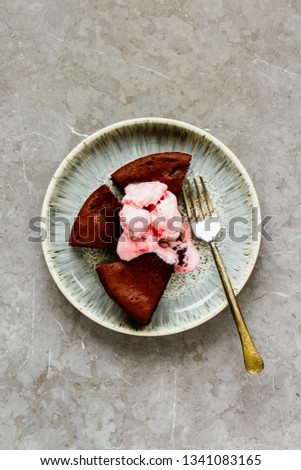 Slices of chocolate coffee cake with pink ice cream in plate, top view, flat lay - Image
