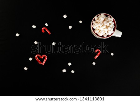 Christmas caramel and marshmallows on a black background. Selective focus.