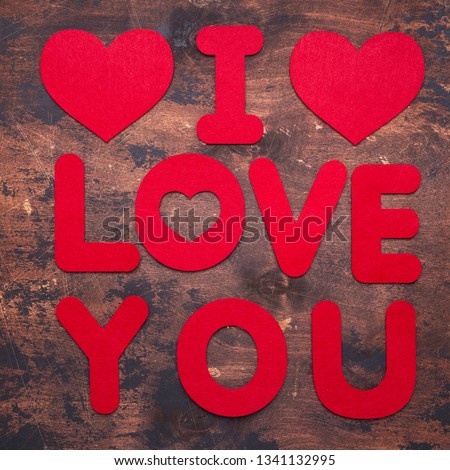 Words I Love You and textile hearts on old wooden background Red textile letters Top view Copy space