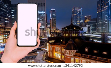new technology and application support travel concept from beauty business woman hand show new smart phone with lighting on street at tokyo station background