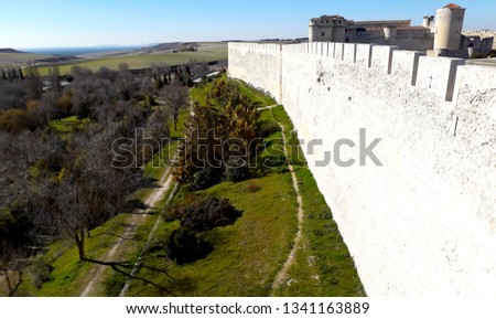 background with exterior stone wall of castle and with green area 