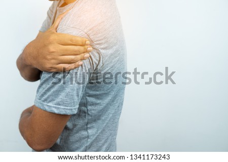 Man with pain in shoulder and upper arm, Ache in human body , closeup  Royalty-Free Stock Photo #1341173243