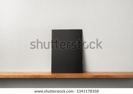 Design concept - back view of black magazine stand on bookshelf and grey wall for mockup, not 3D render
