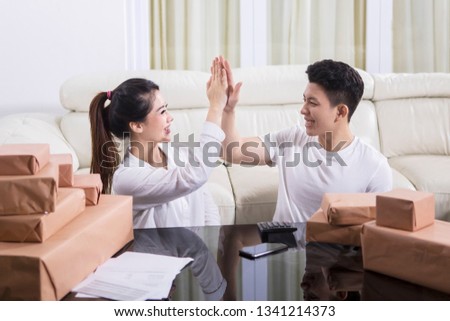 Picture of happy woman clapping hands with her husband to celebrating their success online business