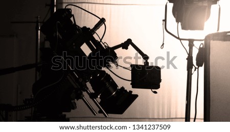 Behind video camera in film or movie production on tripod and professional gear which shooting in location or studio with crew team and prop or set and ready to online live broadcast or tv on air