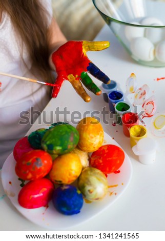 Beautiful little girl hands, painting Easter eggs color brush. Child portrait and kids hobby concept. Holiday interesting accessories. Amazing people picture.