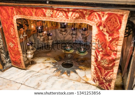 A silver star marks the site of the birth of Jesus in a grotto underneath Bethlehem's Church of the Nativity Royalty-Free Stock Photo #1341253856