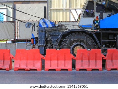 Red plastic barriers blocking near the road during construction.