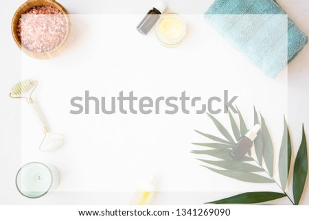 Spa still life with bath salt, jade roller, towel, natural skincare products, candle , soft blur with copy space, spa with copy space frame top view, wellness concept 