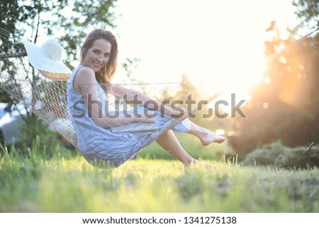 Beautiful young girl lying and reading a book in the summer outdoors
