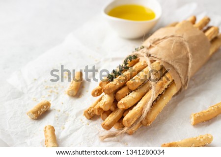 Italian grissini or salted bread sticks on a light stone background. Fresh italian snack. Copy space.  Royalty-Free Stock Photo #1341280034