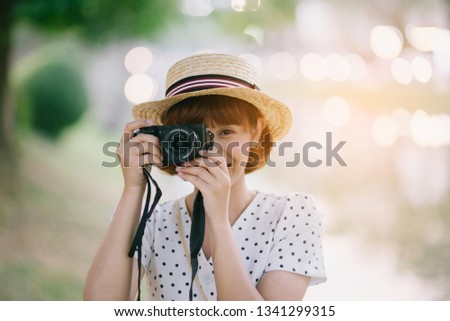 Portrait of young charming woman holding photocamera