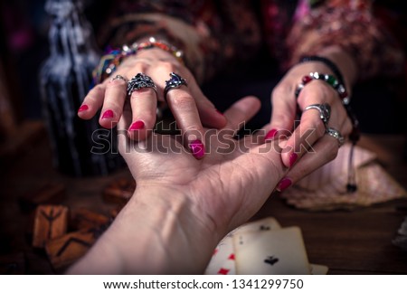 Gypsy fortune teller predicts the future by chiromancy Royalty-Free Stock Photo #1341299750