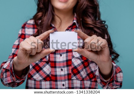 Closeup picture of woman holding white credit card isolated over the blue background.