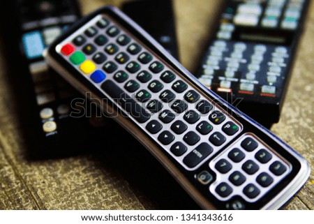 Close up of remote controls for TV, Video and stereo music system on wood table
