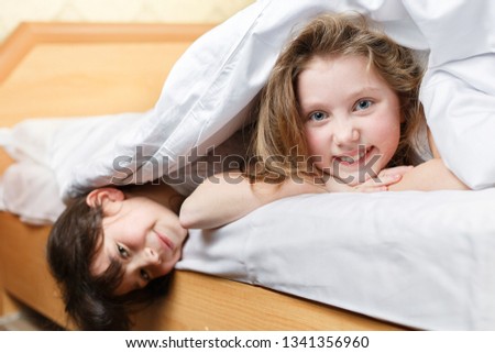 sisters playing in the bedroom, two cute little girls fooling around on the bed